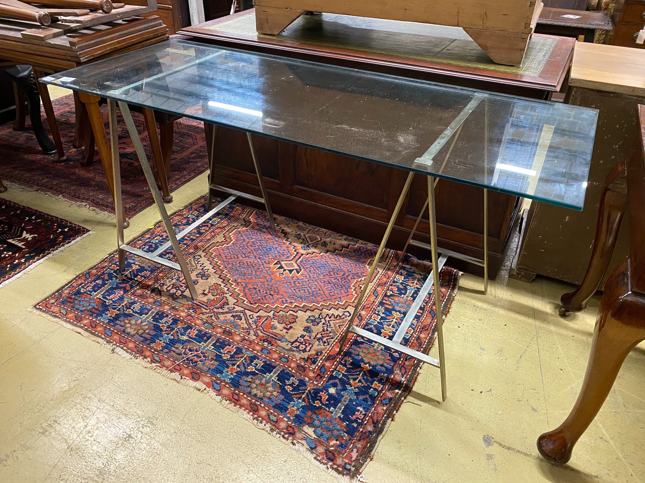 A contemporary rectangular plate glass topped console table, with a stainless steel base, length 152cm, depth 61cm, height 73cm